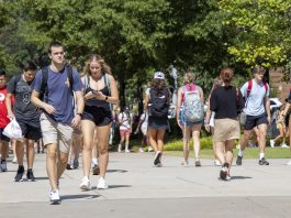 Students walking outside on a bright sunny day on campus