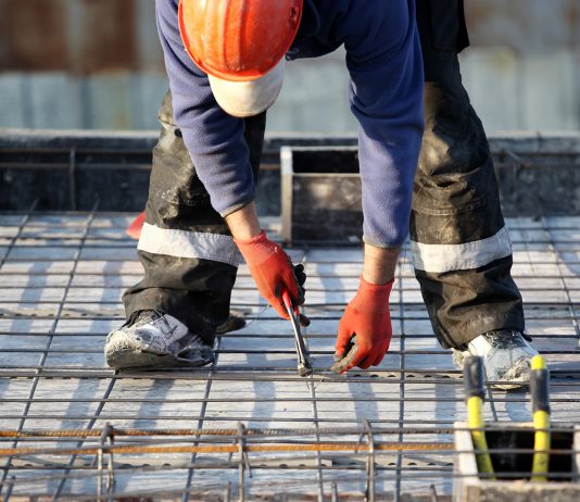 Worker at construction site with rebar