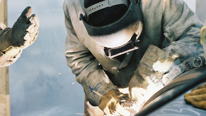 Construction worker welding pipe