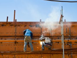 Construction workers welding ship