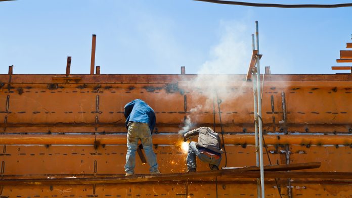 Construction workers welding ship
