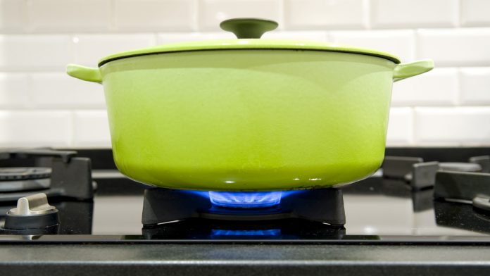 green cast iron cooking pot on a gas stove