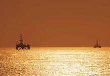 Two offshore oil rigs during sunset