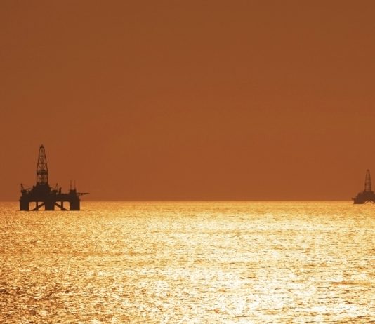 Two offshore oil rigs during sunset