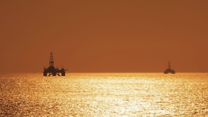 Two offshore oil rigs during sunset