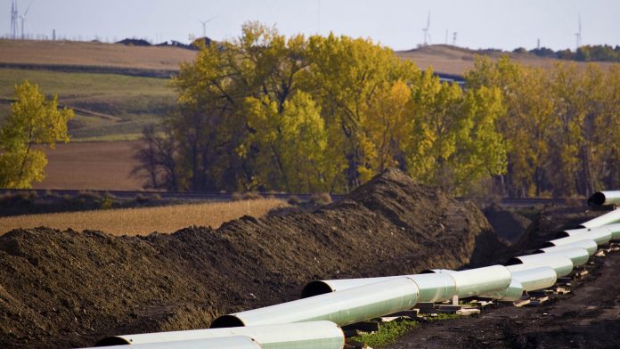 Pipeline construction with wind turbines in the background
