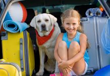 A girl with her Labrador getting ready for vacation
