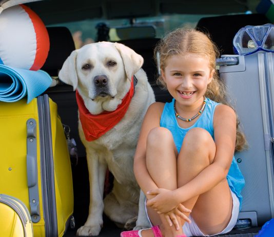 A girl with her Labrador getting ready for vacation