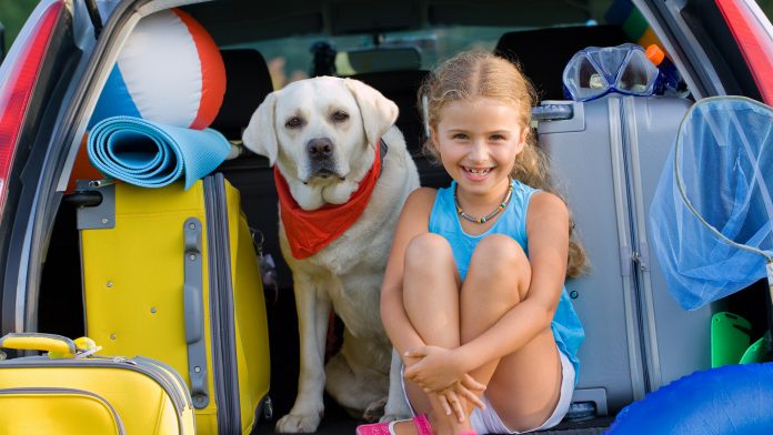 A girl with her Labrador getting ready for vacation