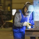 Two steel construction workers welding metal