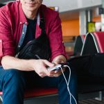 Man charging phone at airport