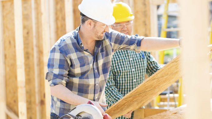 Construction Workers Cutting Plywood