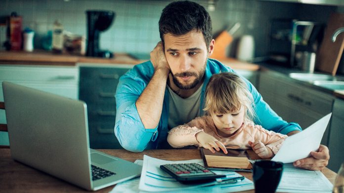 Father and Daughter Sitting in the Kitchen with Bills