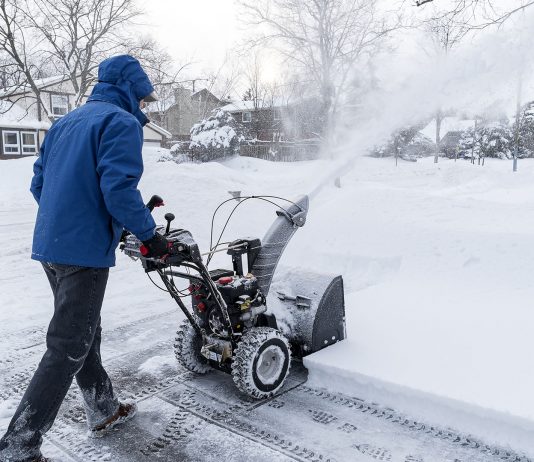 Man clearing snow with a snow blower