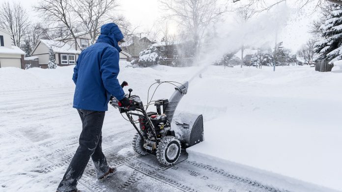 Man clearing snow with a snow blower