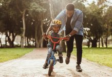 Father teaching his son cycling at park