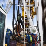 Oil Workers Climb a Rig