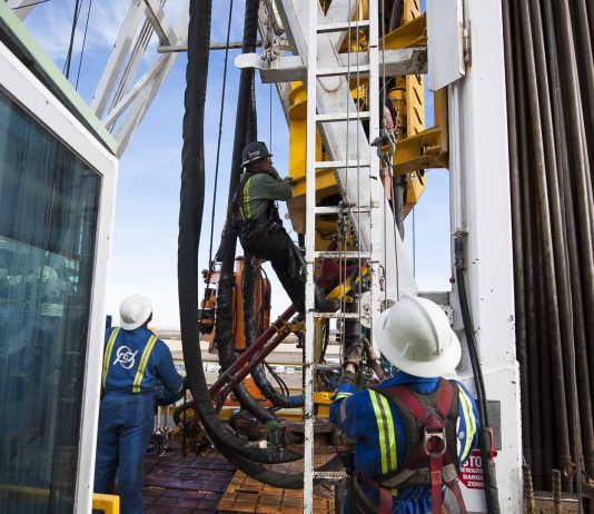 Oil Workers Climb a Rig