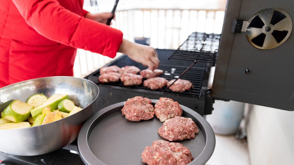 Woman Cooking Meat on Propane Barbecue Grill