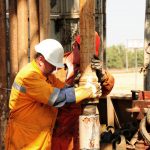 Drilling rig workers in orange uniform