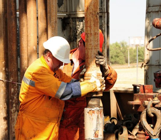 Drilling rig workers in orange uniform