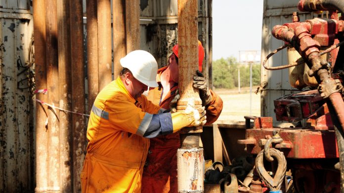 Drilling rig workers in orange uniform