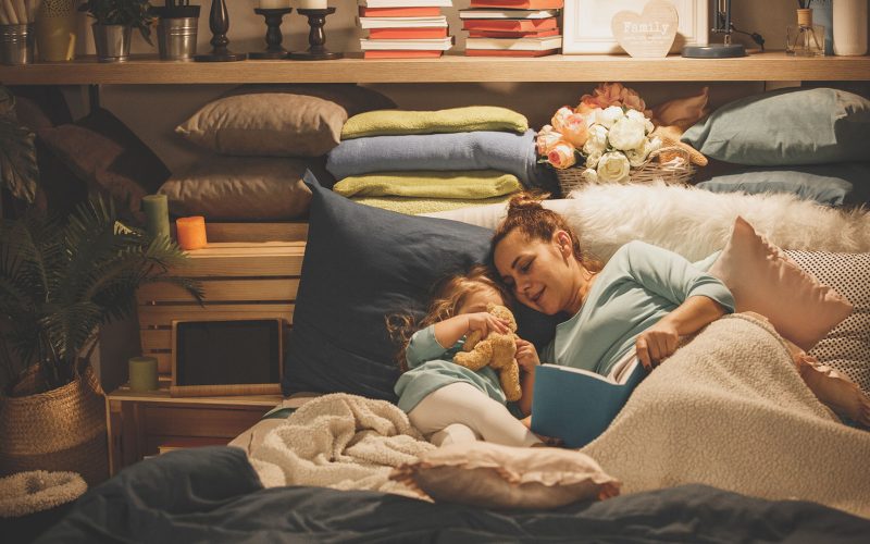 Mother reading a book to her daughter