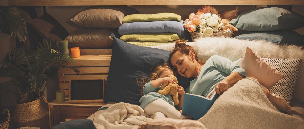 Mother reading a book to her daughter