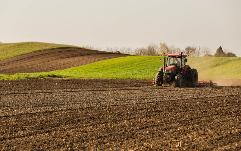 Farmer in tractor preparing land with seedbed cultivator