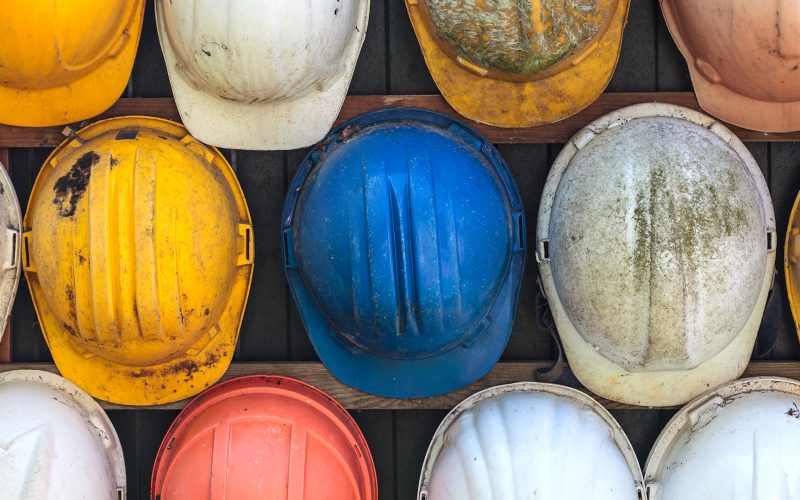 Old and worn construction helmets on wall