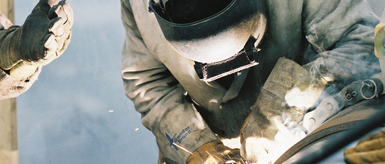 Construction worker welding pipe