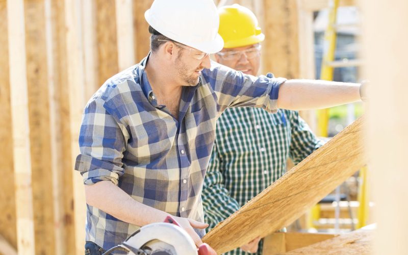 Construction Workers Cutting Plywood