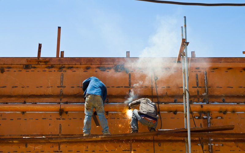 Construction workers welding ship