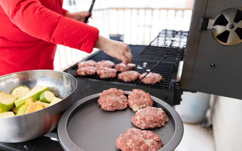 Woman Cooking Meat on Propane Barbecue Grill