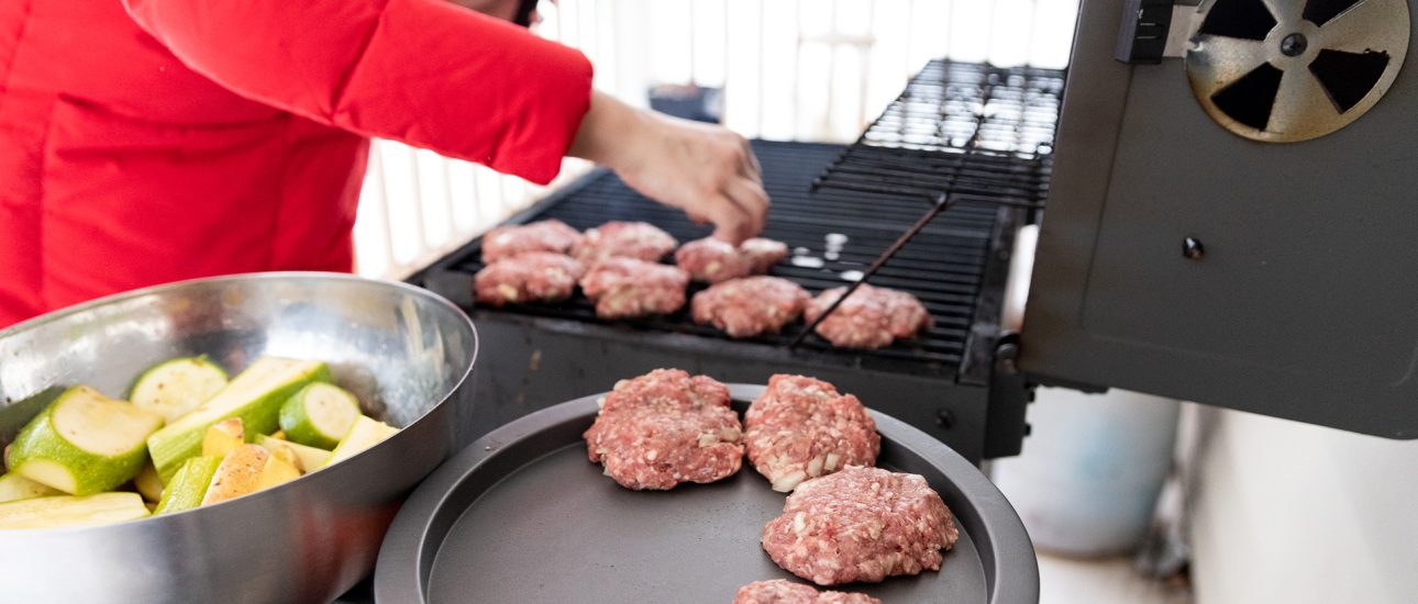 Woman Cooking Meat on Propane Barbecue Grill