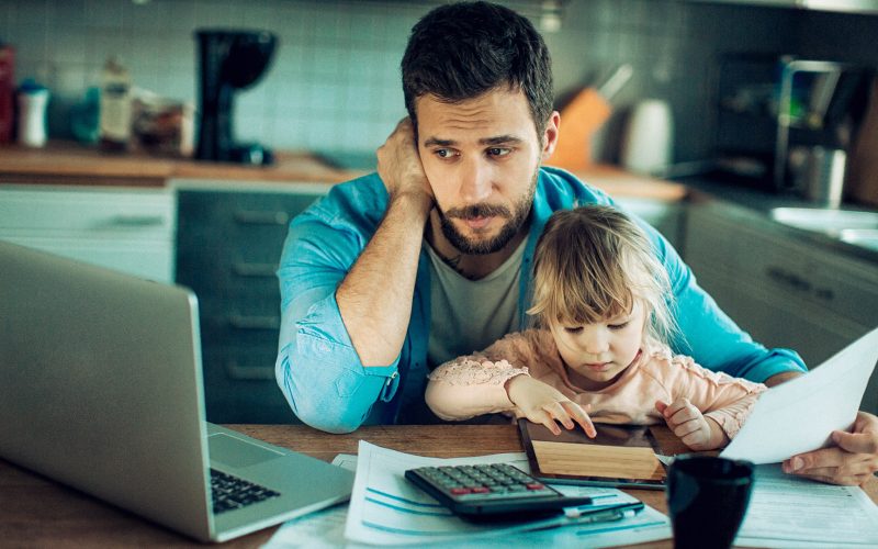 Father and Daughter Sitting in the Kitchen with Bills