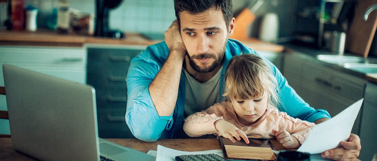 Father and Daughter Sitting in the Kitchen with Bills