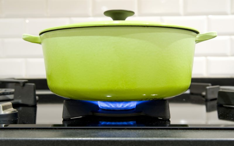 green cast iron cooking pot on a gas stove