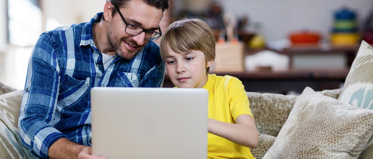 Father helping son on computer