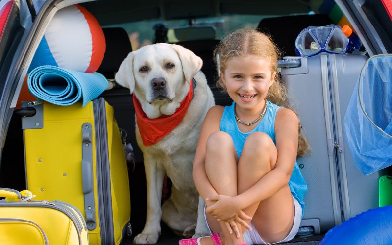 A girl with her Labrador getting ready for vacation