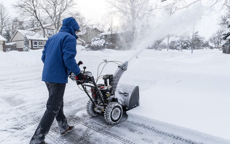 Man clearing snow with a snow blower