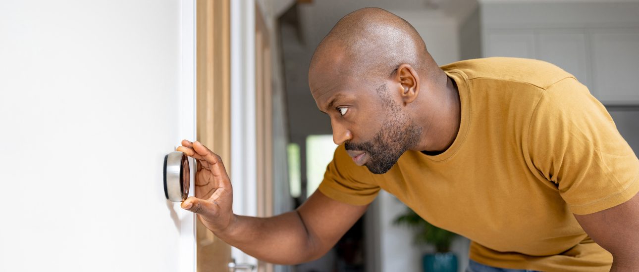 Man adjusting the temperature on the thermostat of his house