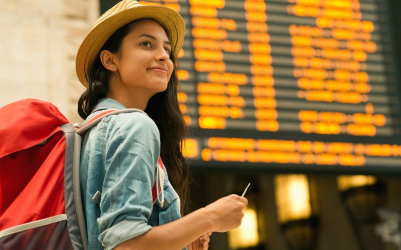 Young woman checking her train in time board