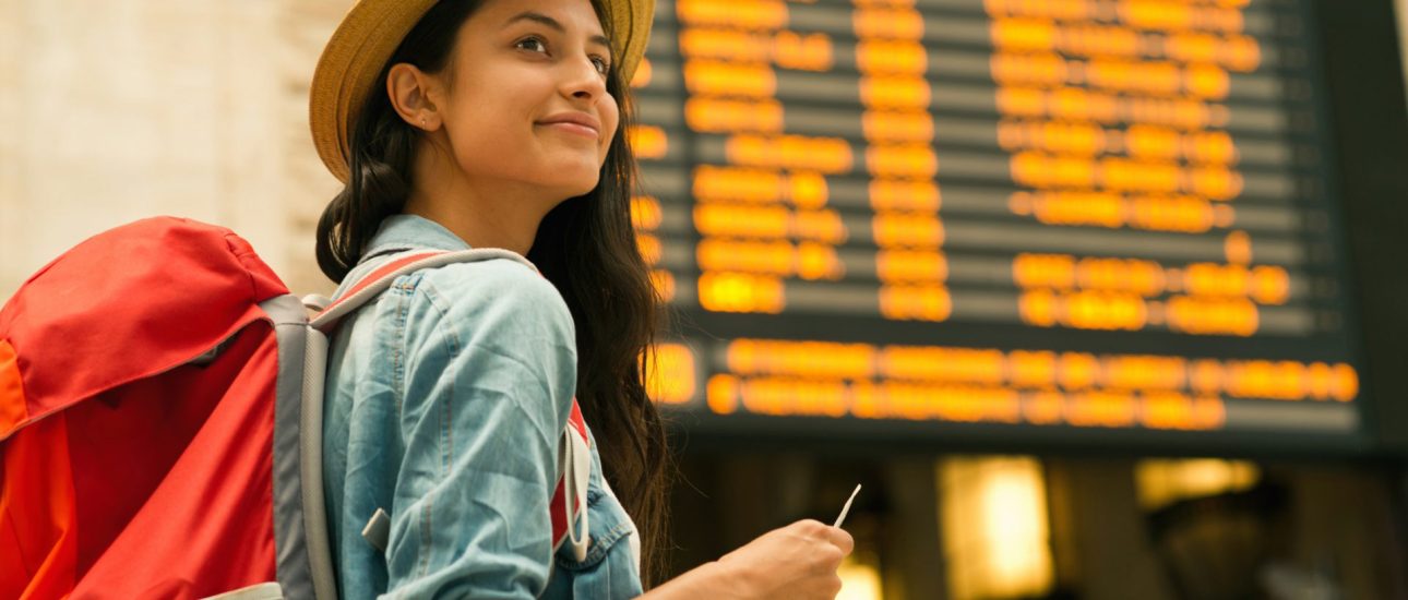 Young woman checking her train in time board