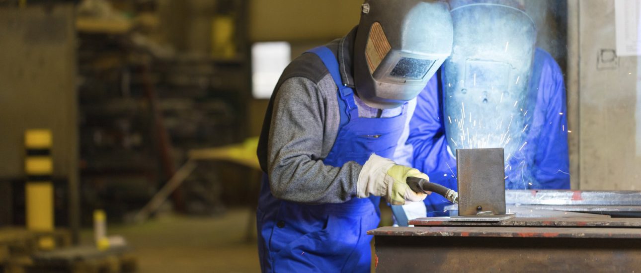 Two steel construction workers welding metal