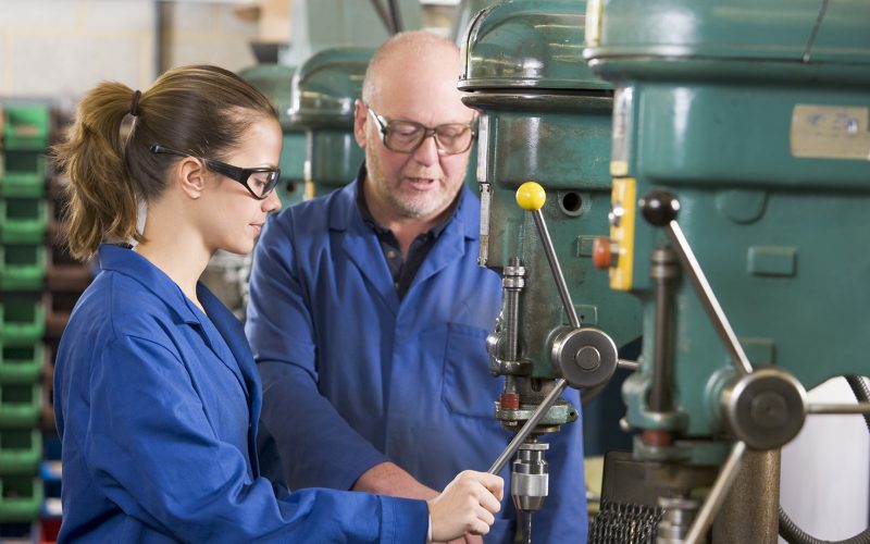 Two machinists working on machine