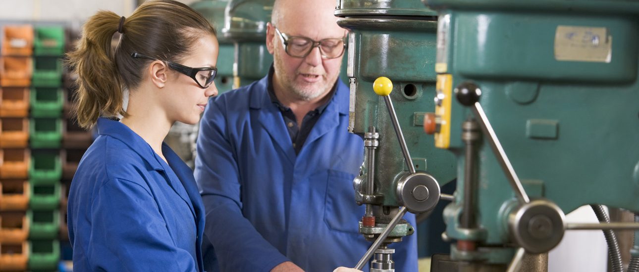 Two machinists working on machine