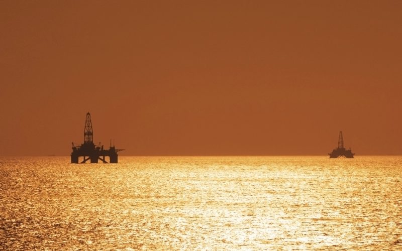 Two offshore oil rigs during sunset