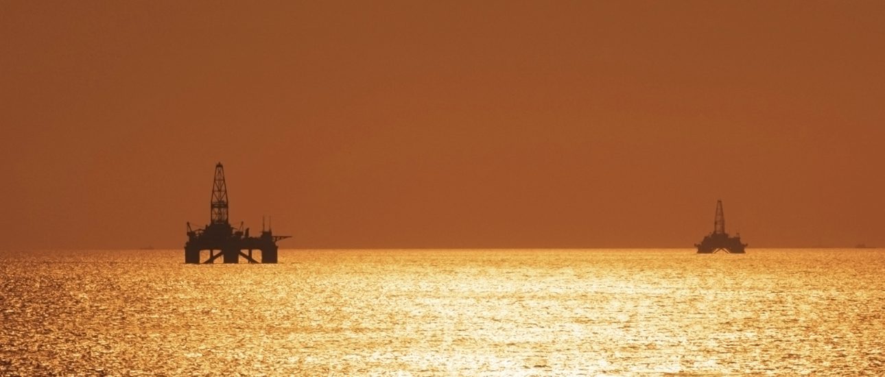 Two offshore oil rigs during sunset