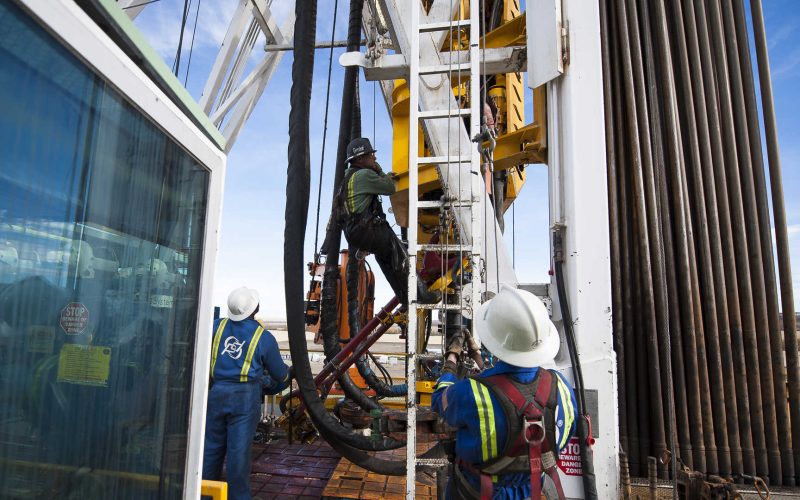 Oil Workers Climb a Rig